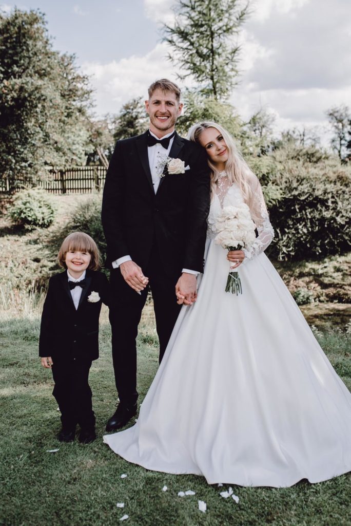 Wedding ceremony kiss showing full gown after expert bridal alterations