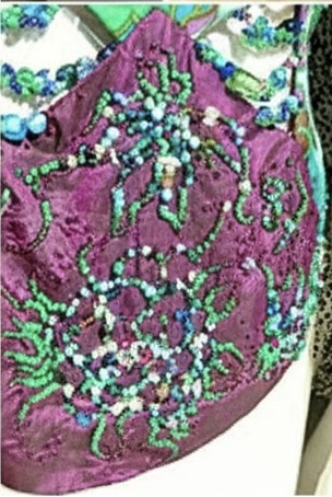 Close-up of hand-applied beadwork on purple dupion silk panel