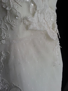 marking cutline on lace wedding dress with pins for shortening