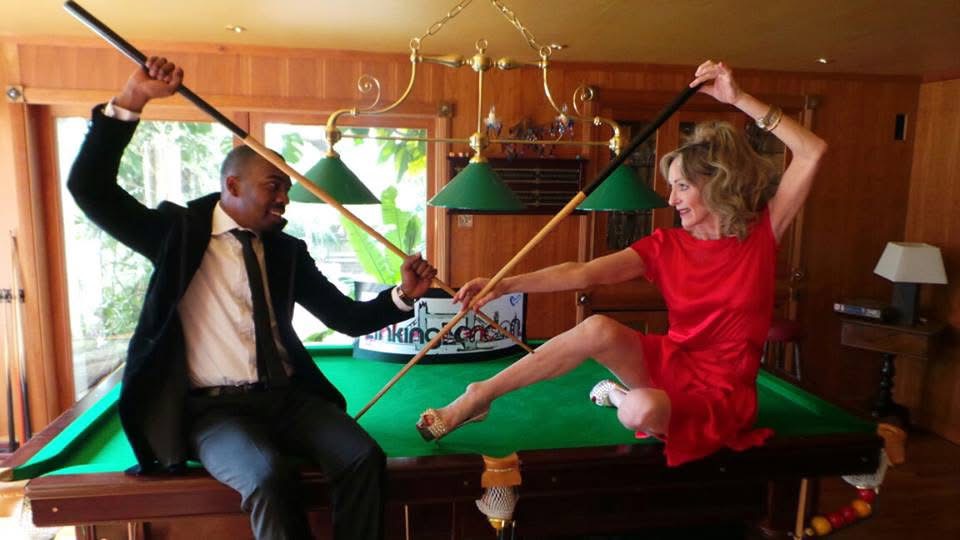 Bespoke dress displayed on pool table showcasing draped silk and structured design