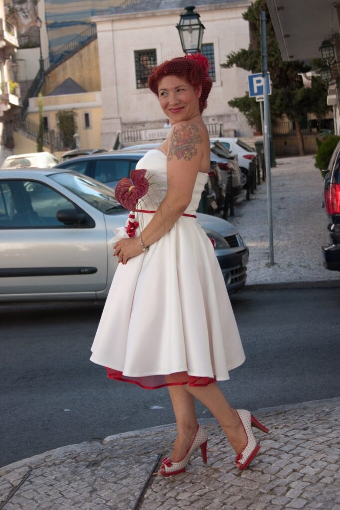 Bespoke wedding dress T length for a bride peekaboo on hem with red petticoats and ribbon edge