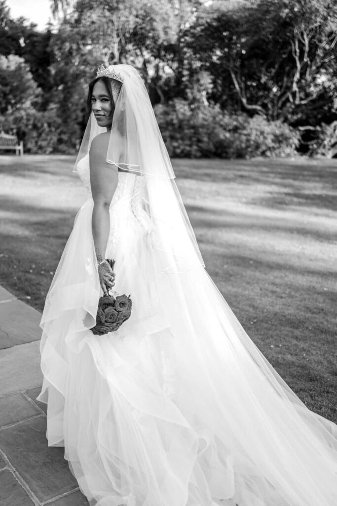 Bride wearing altered WED2B wedding dress with couture modesty panel and reconstructed neckline cathedral veil