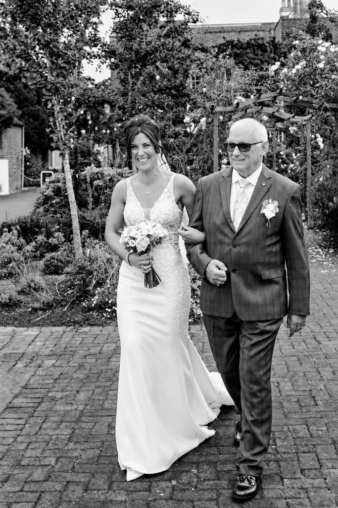 Bride and dad walking after bridal alterations and suit tailoring