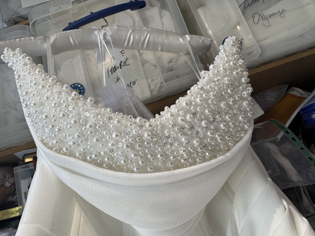 Hand-beaded décolleté detail close up on Edit By Aurora Janey wedding dress during Crawley bridal alterations