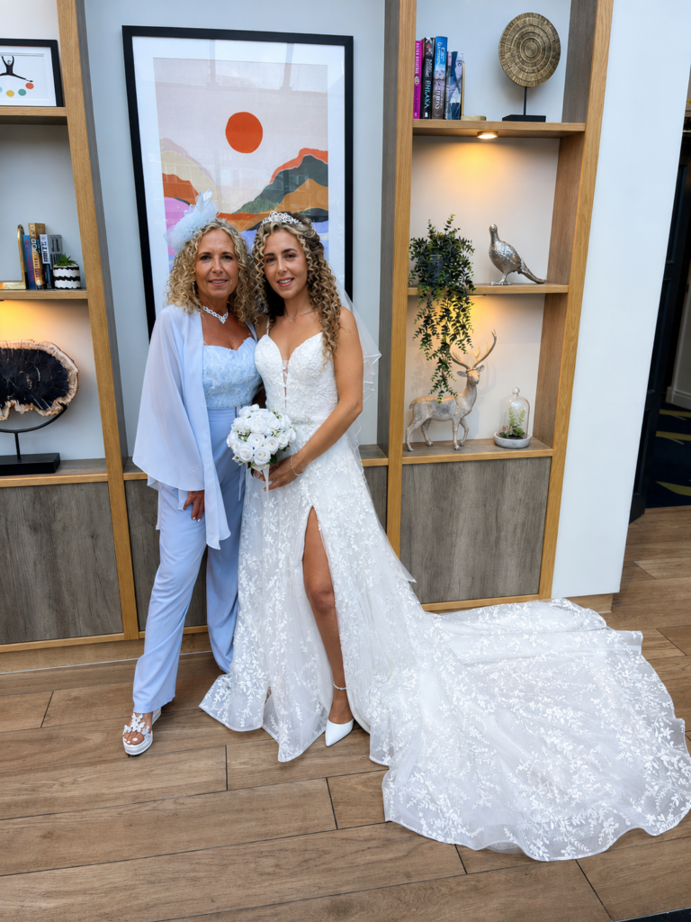 Bride standing with mother in altered WED2B wedding dress with softened silhouette and split