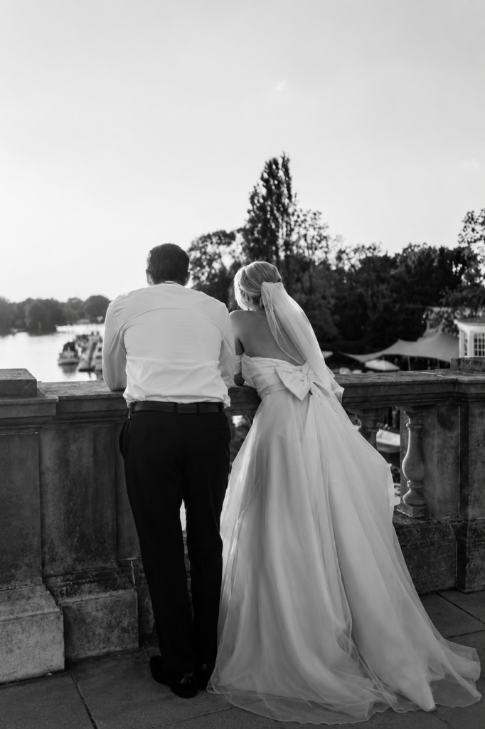bride and groom looking over the bridge