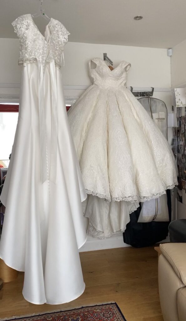 Comparison showing the scale of a heavily embellished gypsy wedding dress beside a standard wedding gown