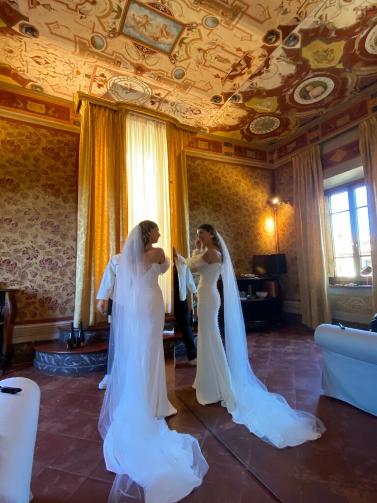 Bride wearing a minimalist crepe wedding dress with bespoke pleated tulle sleeves during wedding morning preparations