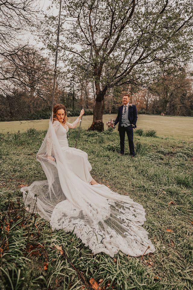 Bride wearing cathedral veil after sitting on a swing