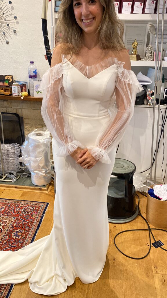 Front final fitting during couture bridal sleeve reconstruction using pleated illusion tulle