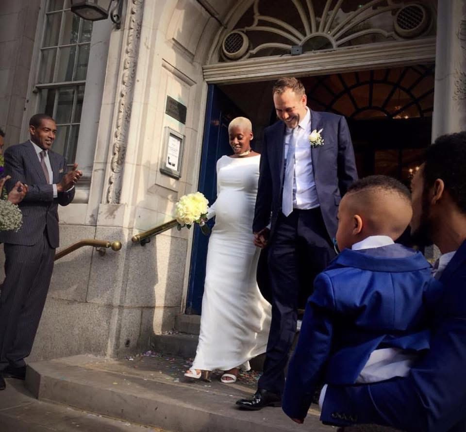 Heavily pregnant bride wearing fitted crepe wedding dress with train after alterations