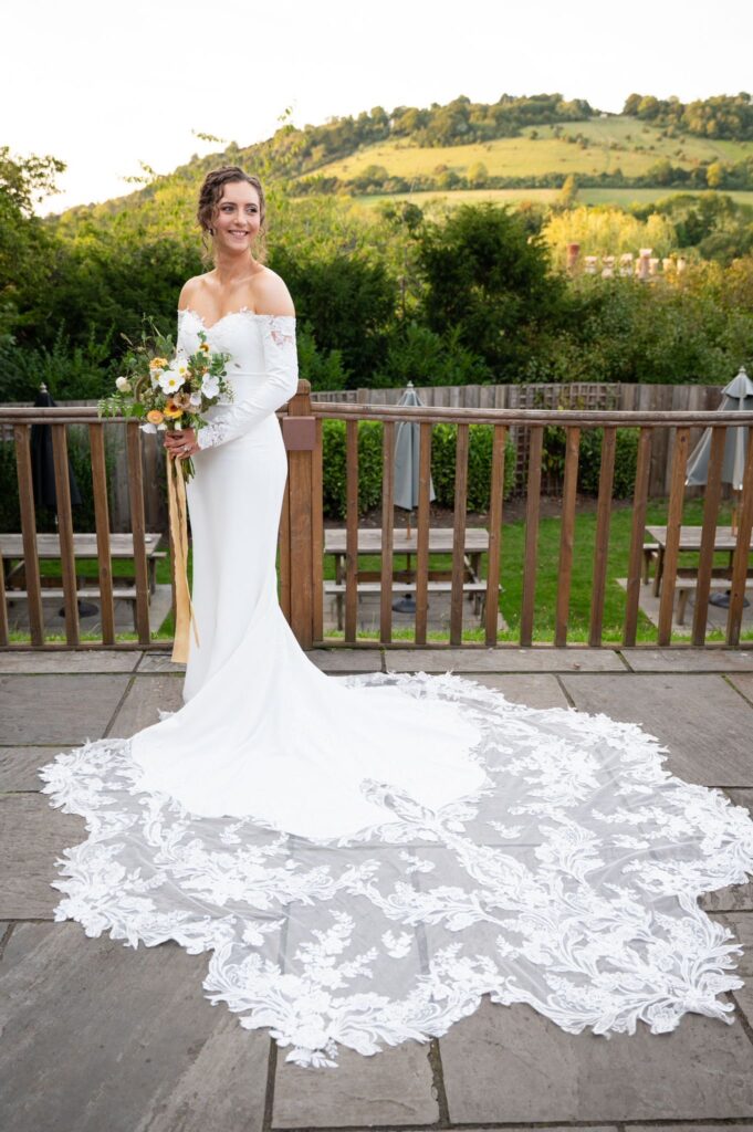 Bride walking in couture altered Maggie Sottero wedding dress with cathedral lace train