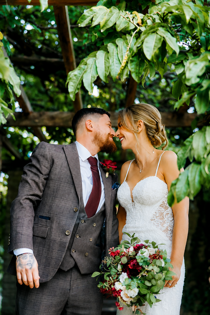 Bride wearing altered Martina Liana close up of wedding dress with dramatic lace train and veil