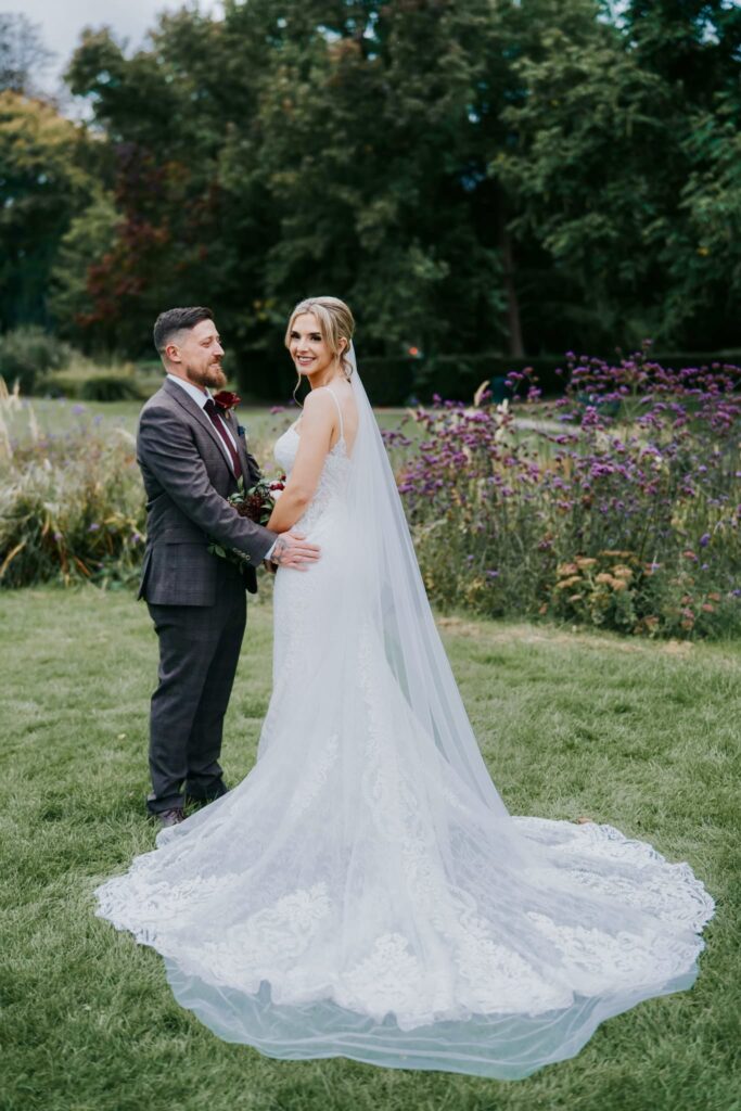 Bride wearing altered Martina Liana 1187 wedding dress with dramatic lace train and veil