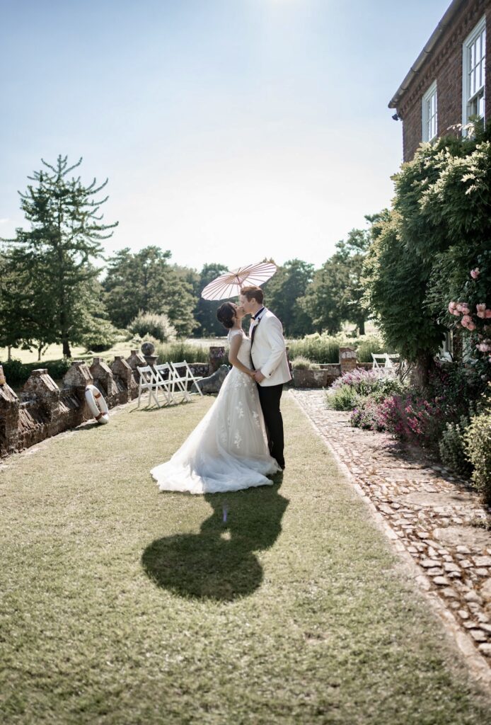 bridal alterations showing refined bodice contouring and soft layered skirt structure kissing under parasol