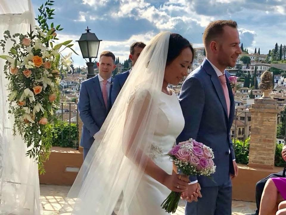 Bride wearing restructured Rosa Clará gown with cathedral veil at destination wedding in Granada