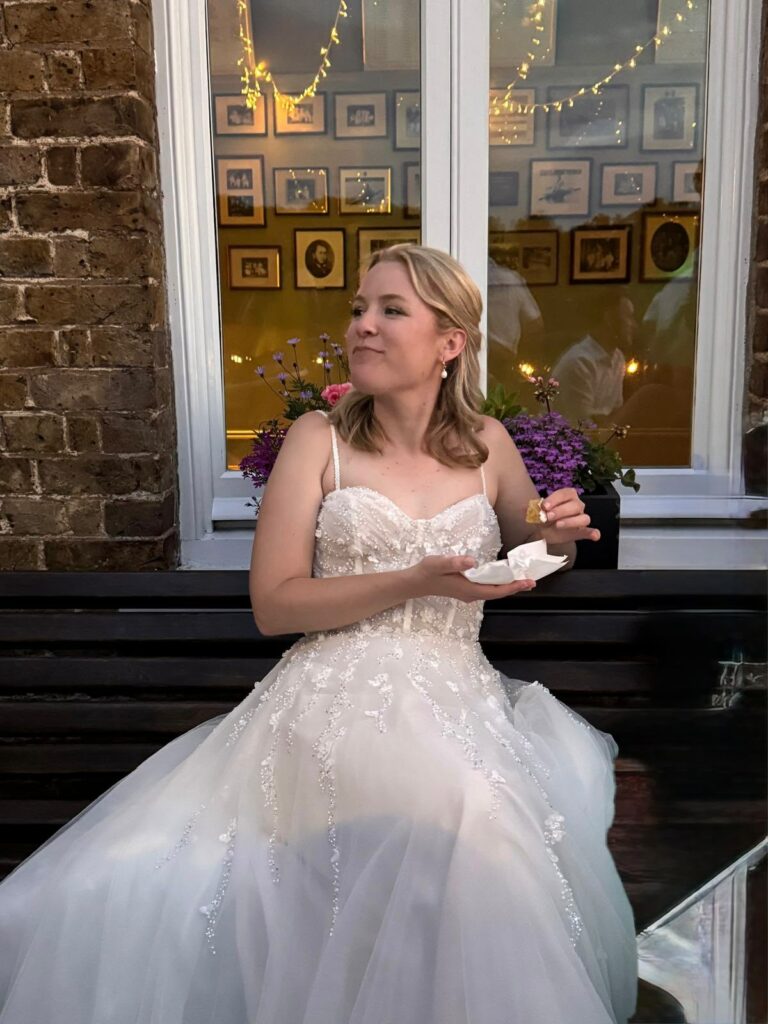 Bride wearing her altered Justin Alexander Florita wedding dress eating cake.