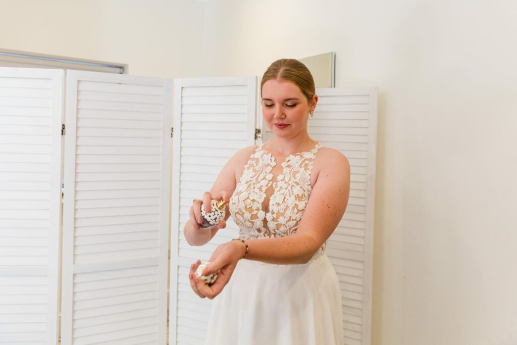 Redhill bride wearing altered Morilee wedding dress putting on perfume