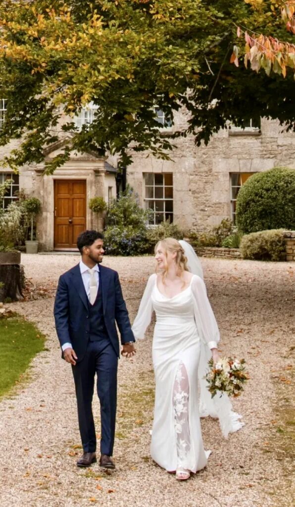 Bride wearing a Veni wedding dress after couture bridal alterations in Dorking with bespoke balloon sleeves with groom.