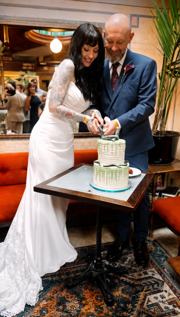Luxe Privée Beccs wedding dress with lace train and veil following corrective bridal alterations couple cutting cake