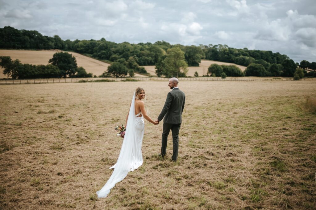 Redhill bride wearing a Catherine Deane Kin gown after couture bridal alterations, posing with her groom together