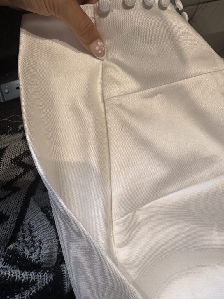 Close up of wedding dress seam reconstruction showing couture level alteration restitching