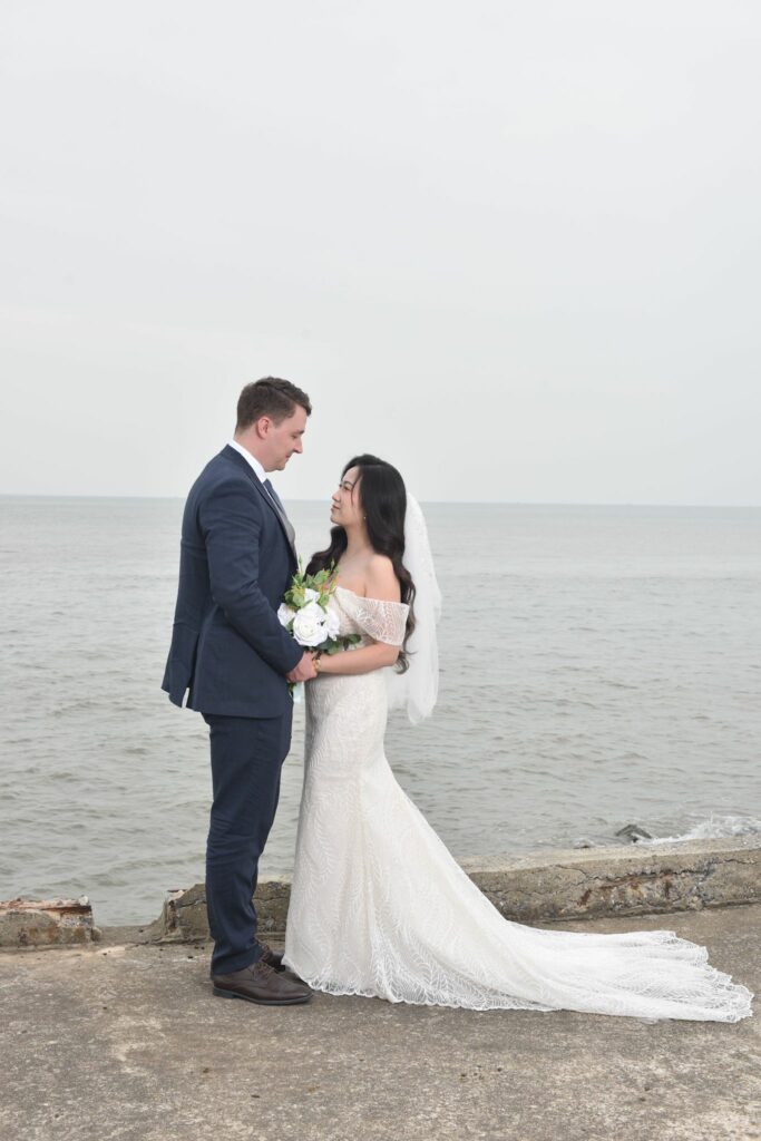 Petite bride wearing altered Monreal Lindsay wedding dress with bespoke Bardot sleeves
Close