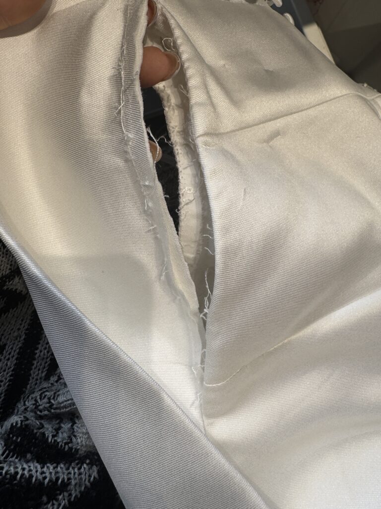 Wedding dress opened up during stitching showing marking and shaping adjustments for couture bridal alterations