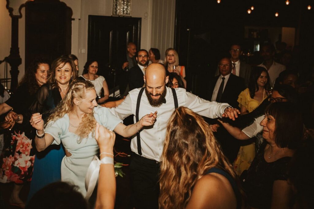 Guests joining the traditional Sousta male dance at the wedding reception