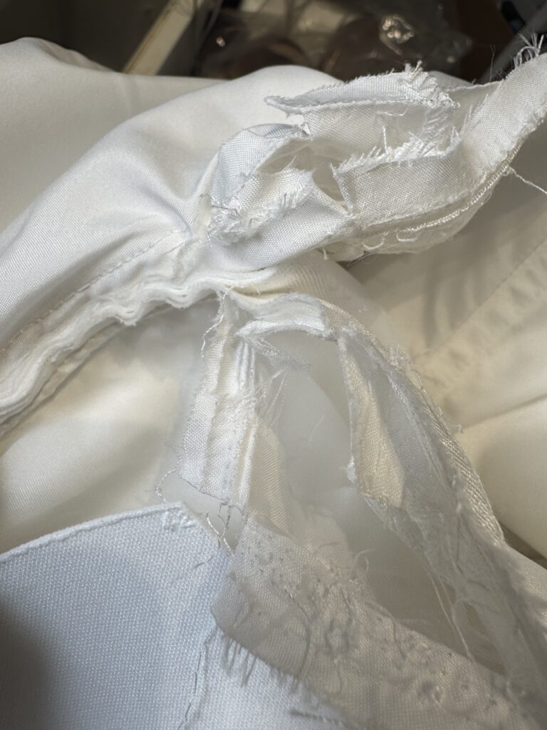 Close up of wedding dress seam reconstruction showing couture level alteration stitching and resewing