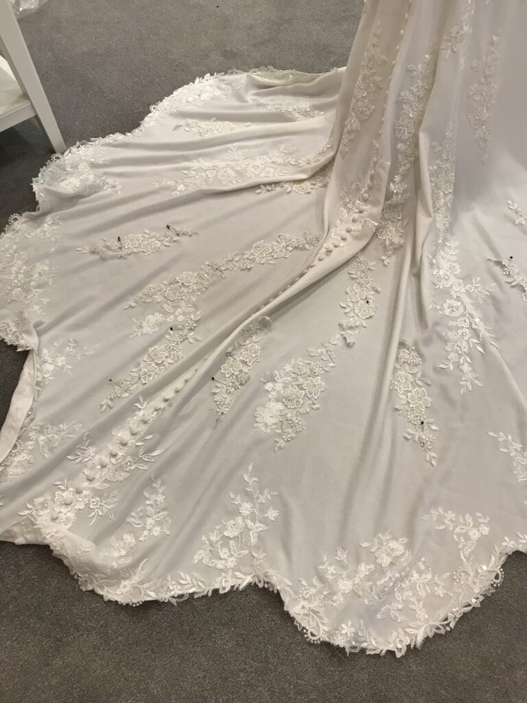 hand sewn 100 individual hand applied applique all over train and hem front and back and along the dress bodice