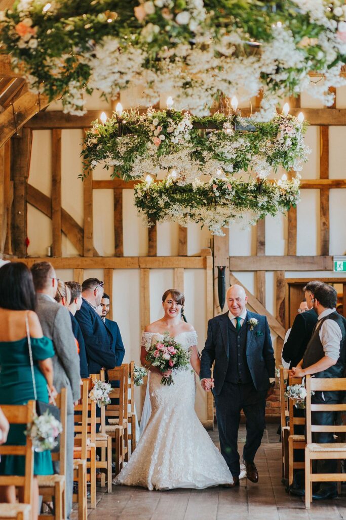 Surrey bride walking down the aisle wearing an altered Anny Lin wedding dress from BRIDE by Aster