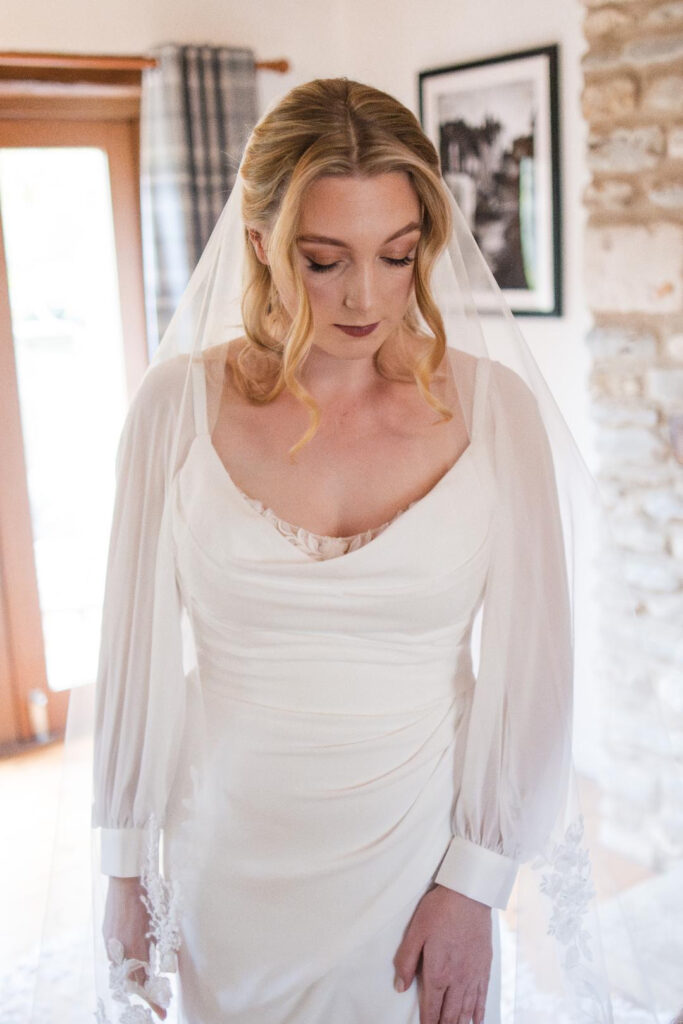 Bride wearing a wedding dress after couture bridal alterations in Dorking with bespoke balloon sleeves broadened straps shortened lace hem