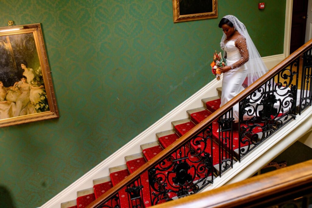 bride coming downstairs looking stunning in her superbly fitted dress