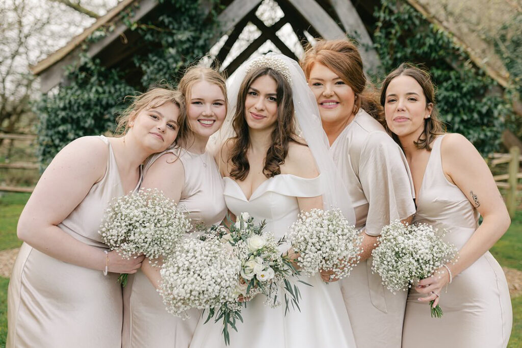 Sarah, a previous WED2B bridal alterations client, pictured as bridesmaid at Georgia’s wedding with bride 