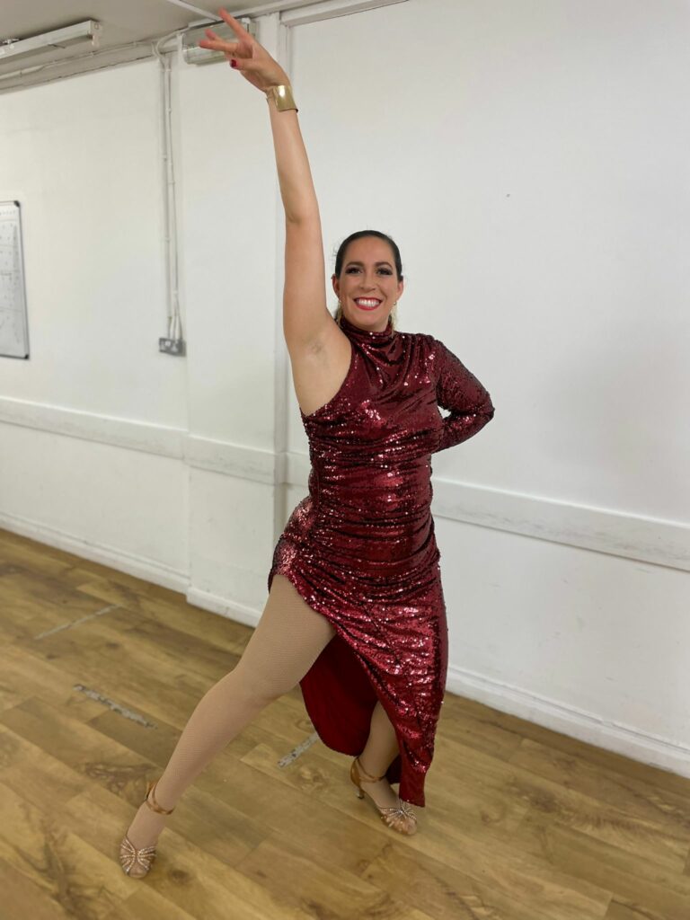 Dance costume alterations on a red sequinned performance dress with a reconstructed split and customised fit for a Bachata dancer.