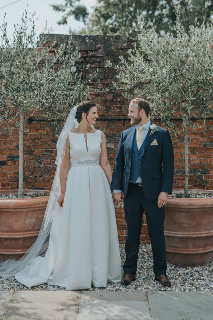 Bride wearing bespoke beaded illusion bolero created from scratch for a Jesus Peiro wedding dress with groom
