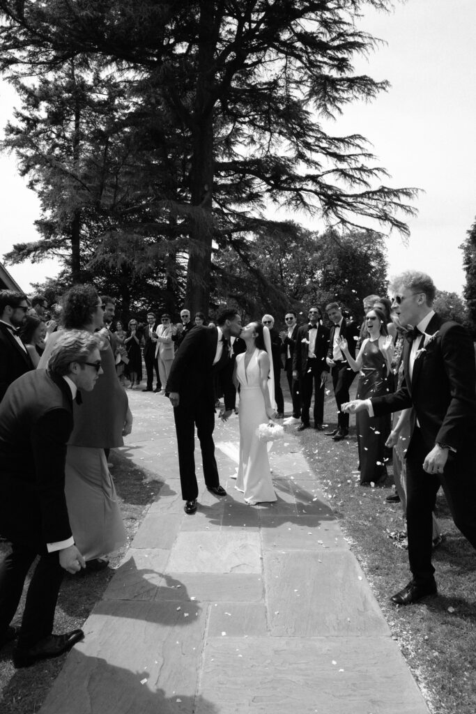 Bride wearing a Made With Love Audrey wedding dress after couture bridal alterations during the confetti celebration first kiss