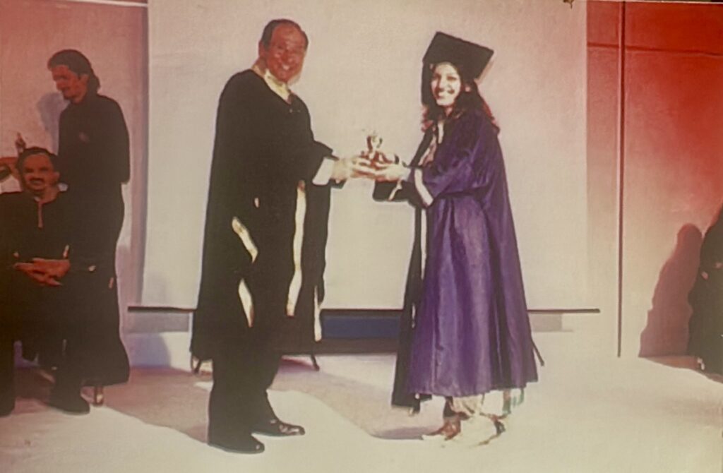 Zenub receiving the Gold Trophy for First Position and Most Outstanding Student from Monsieur Broca, Principal of La Chambre Syndicale de la Couture Parisienne, during a couture graduation ceremony.