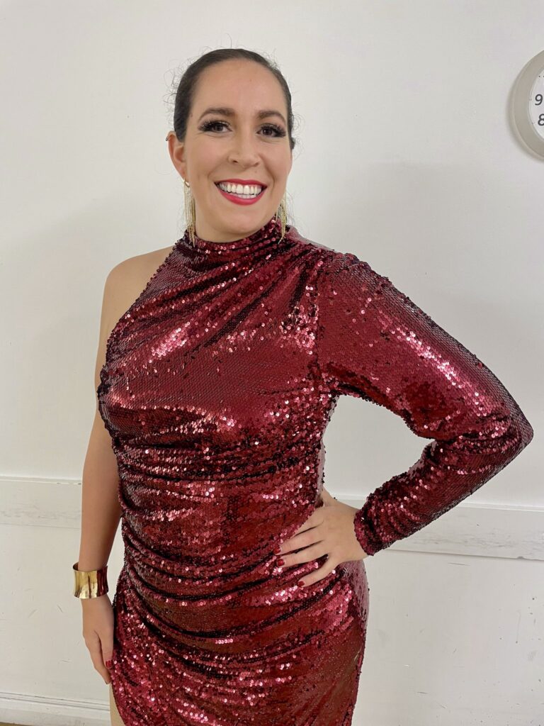 Dance costume alterations on a red sequinned performance dress with a reconstructed split and customised fit for a Bachata dancer couture fitting process.