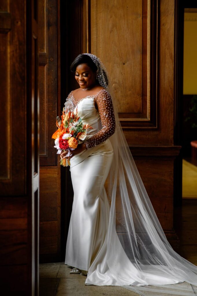 Bride arriving for her wedding in a custom wedding dress expertly altered to fit perfectly near doorway.