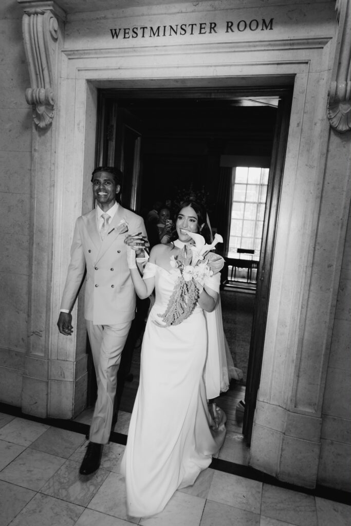 Bridal Alterations Chiswick Four-layer baby rolled hem on a WED2B Luka crepe wedding dress bride walking happily through doorway