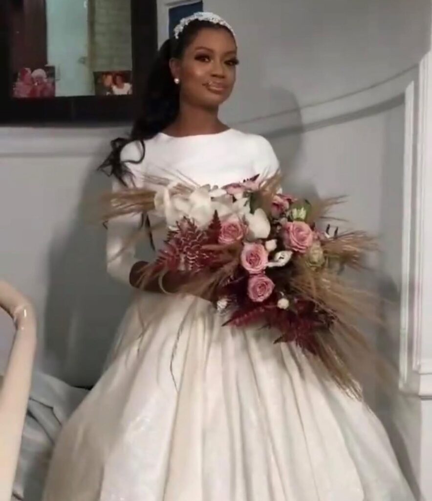 Close-up portrait of a Lagos bride wearing a crystal bridal headpiece and classic satin wedding dress.