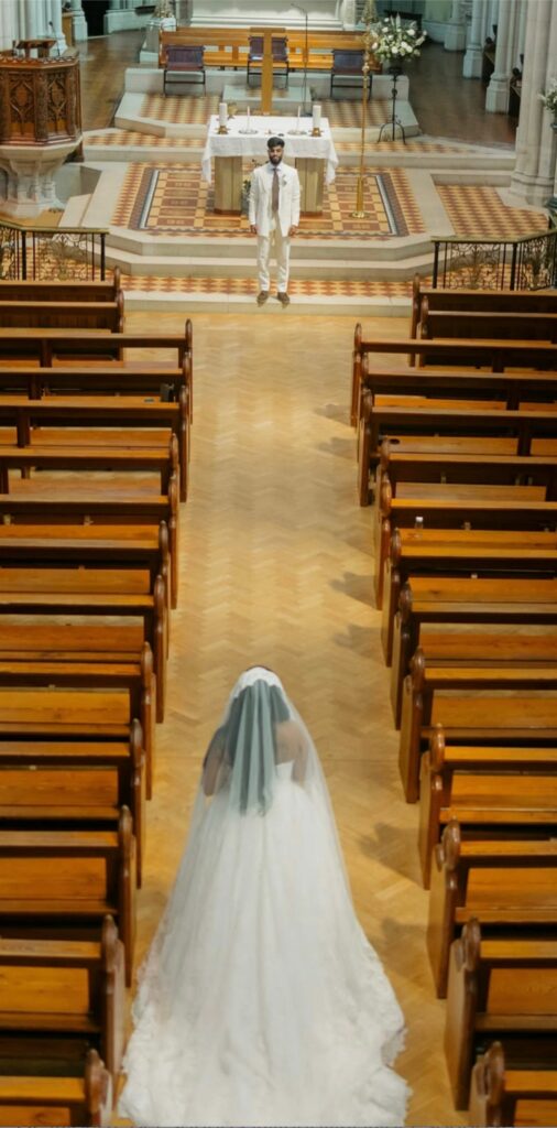Carshalton Bride wearing Allure Abella Carrington wedding dress after couture bridal alterations walking towards groom in Church.