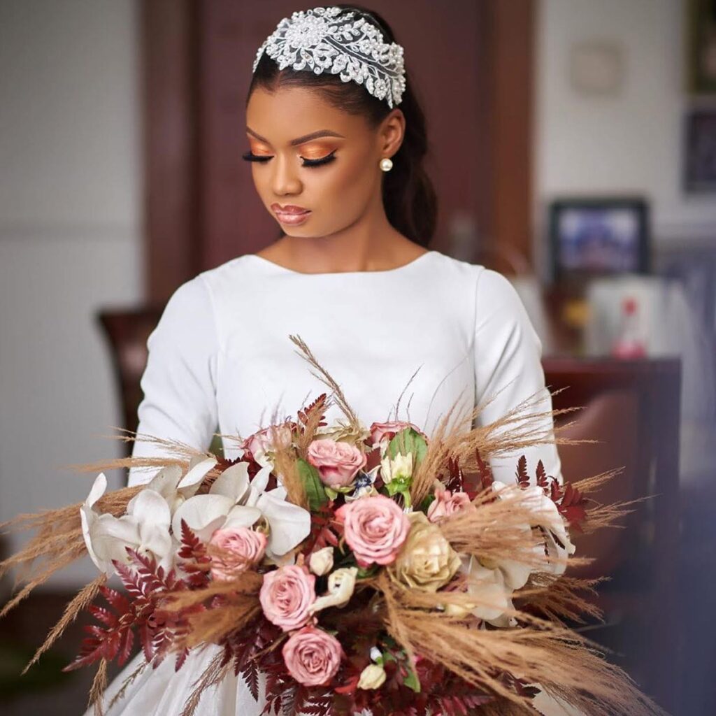 Lagos bride wearing a timeless crepe wedding dress with a full ballgown skirt and statement bouquet.