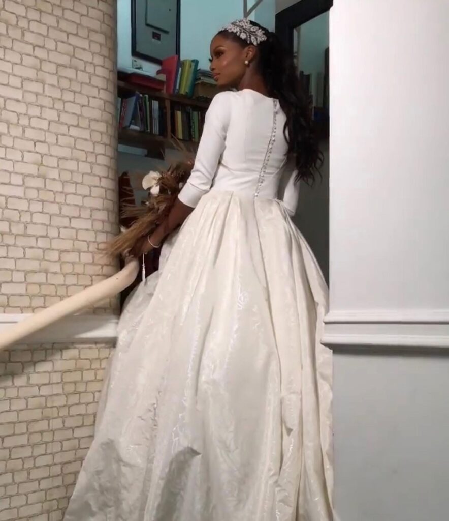 Elegant rear view of a Lagos bride highlighting the fitted bodice, fabric buttons and full satin skirt.