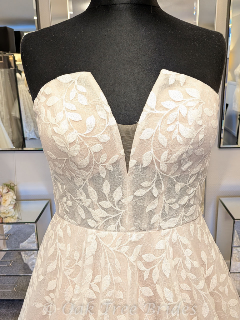 close up original neckline of bridal gown before alterations.