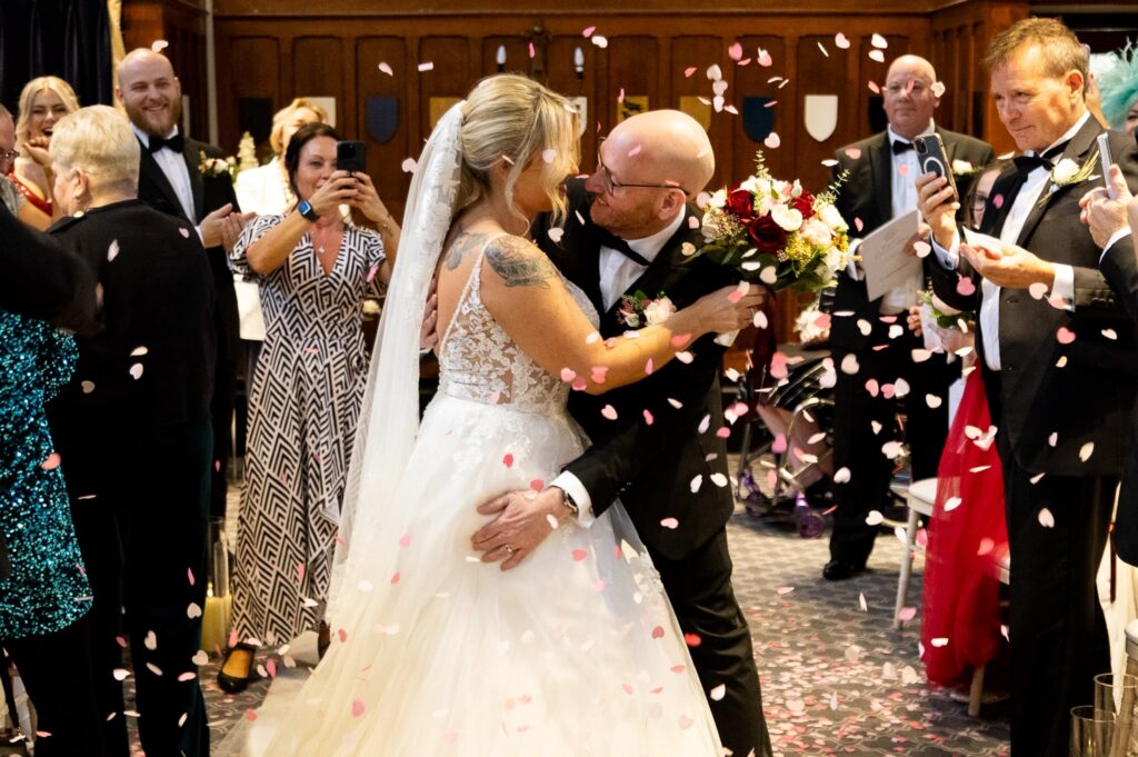 Wed2B wedding dress with tailored fit and bustle created by Sutton bridal specialist confetti at ceremony.