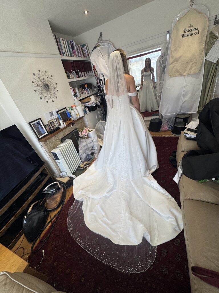 Finished bridal adjustments for Surrey bride in structured satin wedding dress back view.