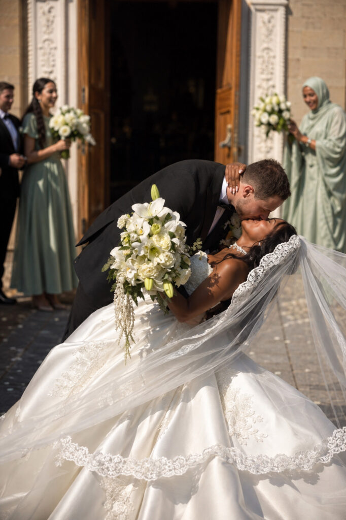 Uxbridge bridal alterations for a completely transformed WED2B Jules wedding dress Bride and groom kissing showing the full Mikado skirt and lace-edged wedding dress train